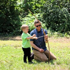 A father helps his son learn archery on the Historic Patuxet Homesite.