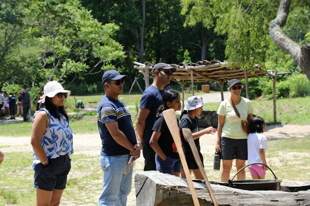 Guests gather in front of the Mishoon on the Historic Patuxet Homesite